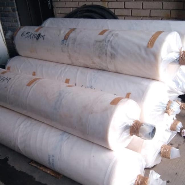 Rolls of 200 micron greenhouse plastic stacked and ready for delivery